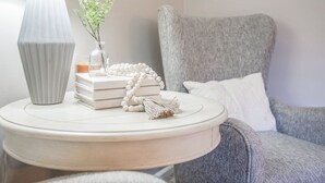 A round white side table with a lamp, books, a beaded necklace, and a small vase with a plant. - Stylish Sedona Condo | Red Rock Views, Modern Comfort & Quiet Location (Sedona)