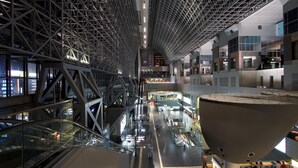 Een moderne binnenruimte met een hoge plafond, glazen balustrades en een centraal atrium.