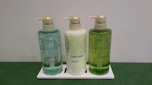 Three bottles of Umineta body care products on a white stand. - Hotel Excellence Kyoto Ekimae (Kyoto)