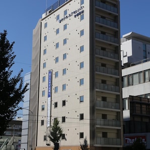 Un immeuble d’hôtel à plusieurs étages, doté d’une architecture moderne, avec une série de fenêtres et de balcons.