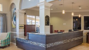 A reception area with a marble counter, a signboard, and a seating area with chairs. - Premium Lake View Condo [cdc Compliant] 1006 (Orlando)