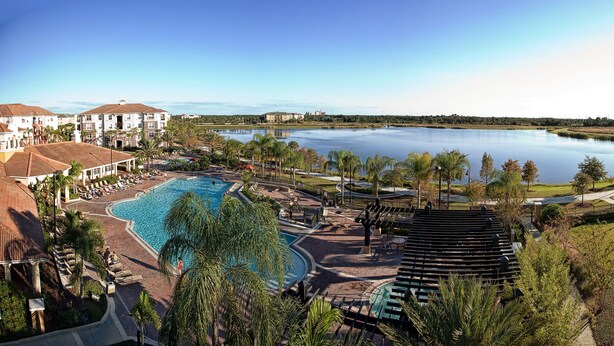 A resort with a large swimming pool, a tennis court, and a view of a lake. - Premium Lake View Condo [cdc Compliant] 1006 (Orlando)