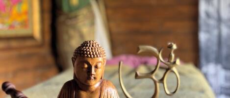 Una estatua de Buda de madera, un cuenco de meditación y el símbolo de Om.