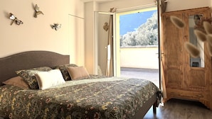 Un dormitorio con una cama, un armario de madera y vistas a árboles fuera.