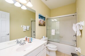 A bathroom with a white sink, toilet, and glass-enclosed shower. - New Listing! Beautiful Vacation Townhome 4007 (Orlando)