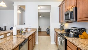 A modern kitchen with granite countertops, stainless steel appliances, and wooden cabinets. - 2 Bed Room Premium [cdc Compliant] l 2005 (Orlando)