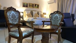A hotel room with a bed, two upholstered chairs, a small round table, and a sofa. - The Autograph Executive Hotel (Lagos)