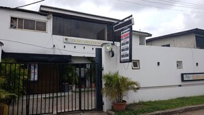 A building with a gated entrance, a signboard with rental prices, and a small window. - The Autograph Executive Hotel (Lagos)