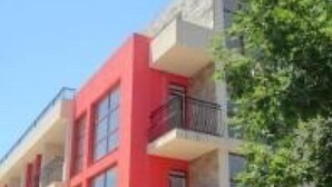 A multi-story building with a red facade and balconies. - Krystal Park studio in Sunny Beach (Sonnenstrand)