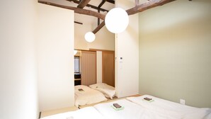 Un dormitorio con dos camas, techo de madera y un espejo.
