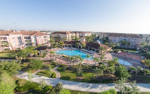 Um resort com piscina central, vários edifícios para hóspedes e áreas ajardinadas.