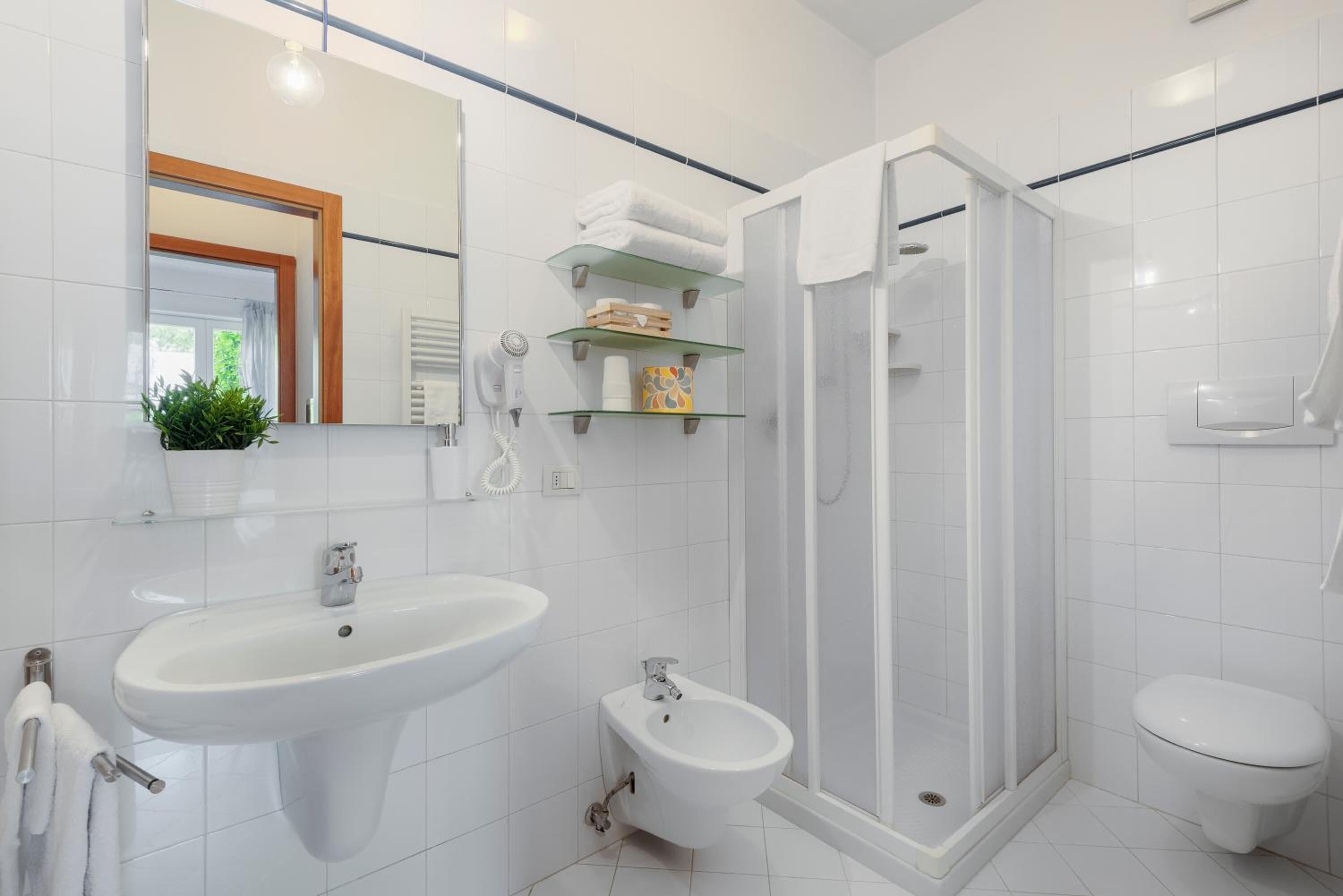 Ein modernes Badezimmer mit Waschbecken, Bidet, Toilette und einer Duschkabine.