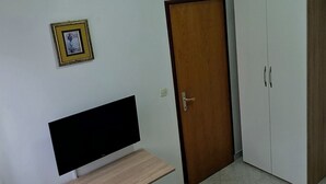 A room with a TV on a wooden shelf, a wardrobe, a door, and a cabinet. - Apartment 2000/28358 (Istria - Fažana), 50m from the beach (Fažana)