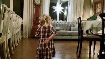 Un niño caminando en una habitación con un reloj grande, una decoración de estrella y un sofá.
