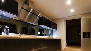 A modern kitchen with dark cabinetry, stainless steel appliances, and a built-in oven. - Magical: Completely renovated farmhouse in the middle of an olive grove (Cotignac)