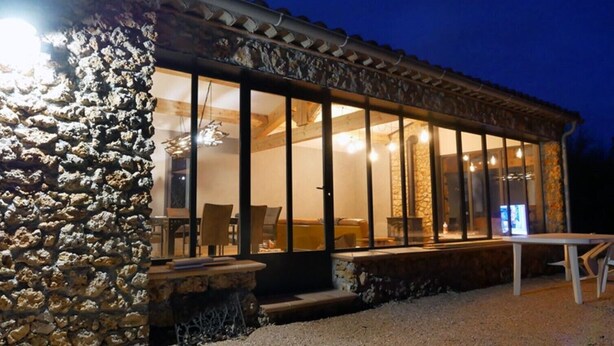 A stone exterior with large windows, a patio area, and a table. - Magical: Completely renovated farmhouse in the middle of an olive grove (Cotignac)