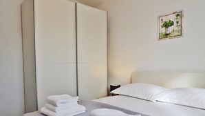 Ett hotellrum med en säng, två sängbord, en garderob och en tavla som hänger på väggen.