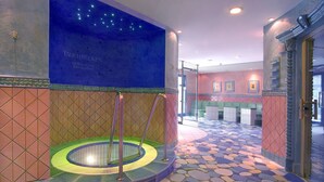 Un área de spa con un jacuzzi circular, una pared azul con estrellas y un suelo estampado.
