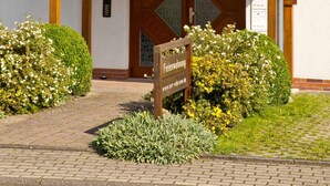 A building with a tiled roof, a wooden entrance, and a sign indicating it's a retirement home. - Apartment 1 - Apartment am-edersee (Edertal)