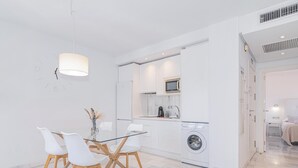 A modern kitchen with a microwave, coffee maker, and washing machine.