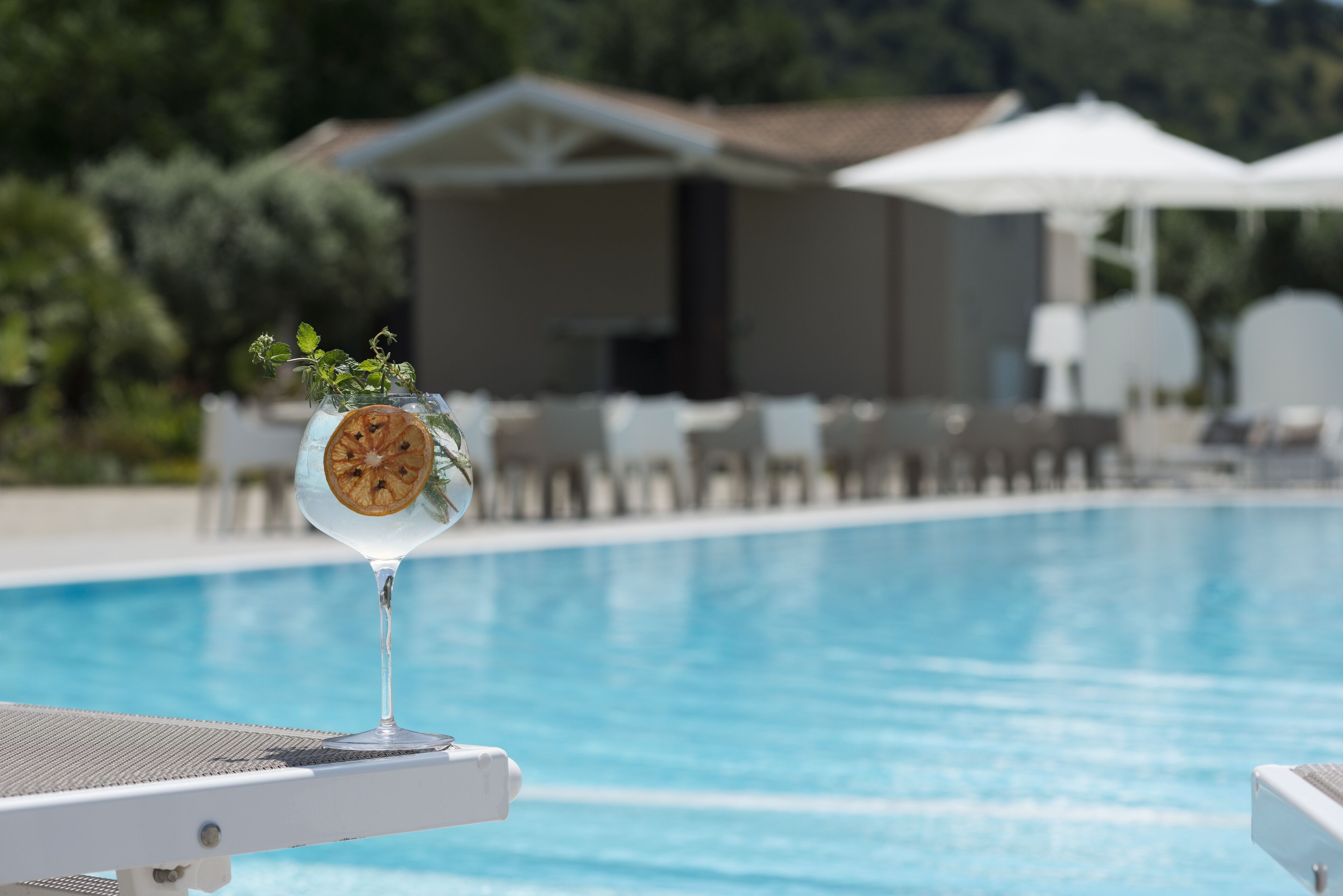Ein Pool mit Liegestühlen und Sonnenschirmen im Hintergrund, mit freier Sicht.