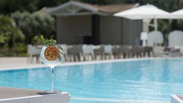 Ein Pool mit Liegestühlen und Sonnenschirmen im Hintergrund, mit freier Sicht.