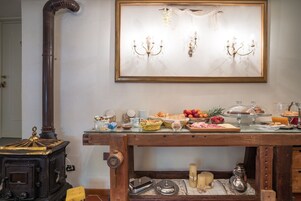 Un bufé de desayuno con distintos alimentos y una estufa antigua.