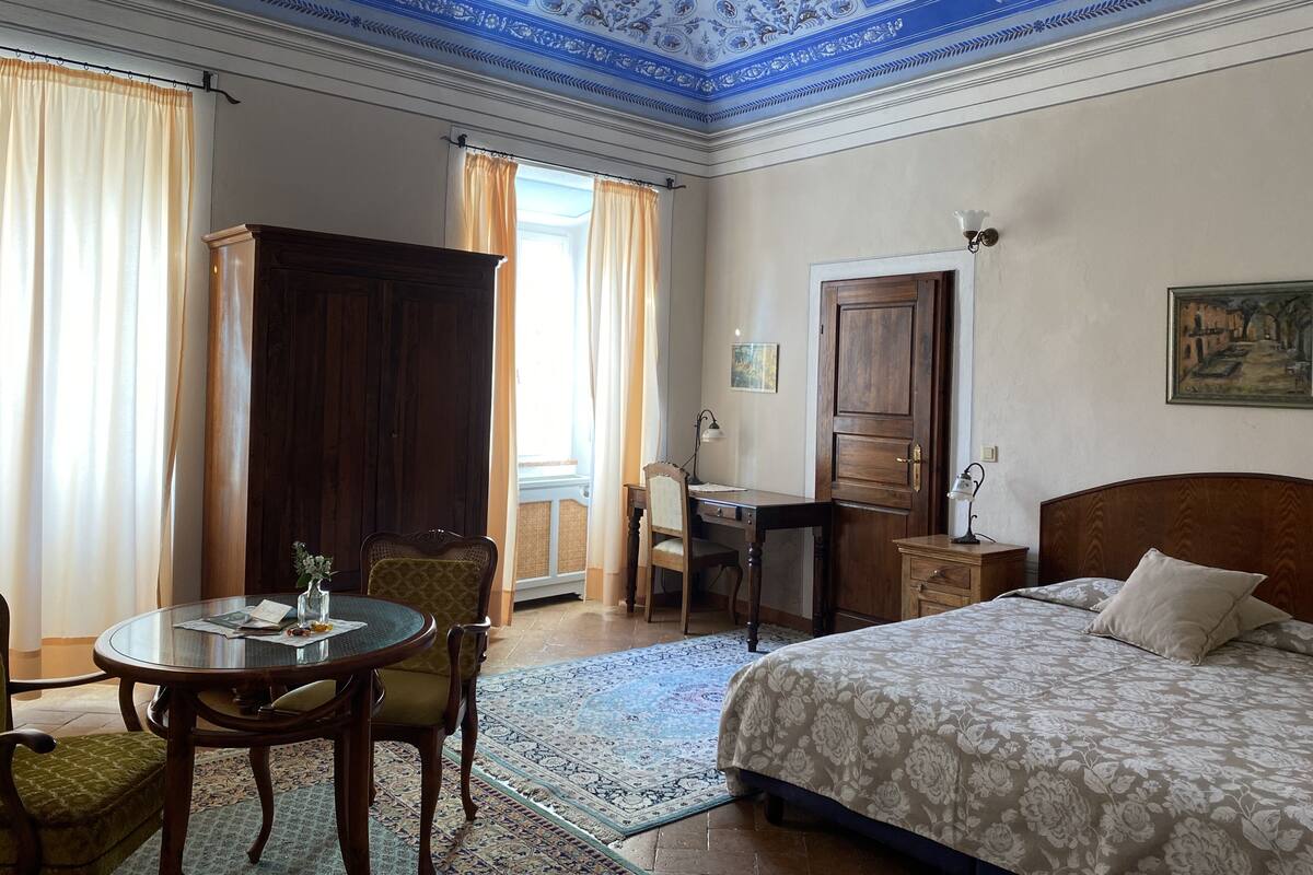 Een hotelkamer met een bed, bureau, stoel en tafel.