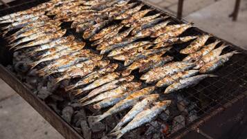A grill with multiple fish being cooked.