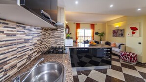 A modern kitchen with a granite countertop, stainless steel sink, and a built-in dishwasher. - B47 - Walkway Beachview Place (Lagos)