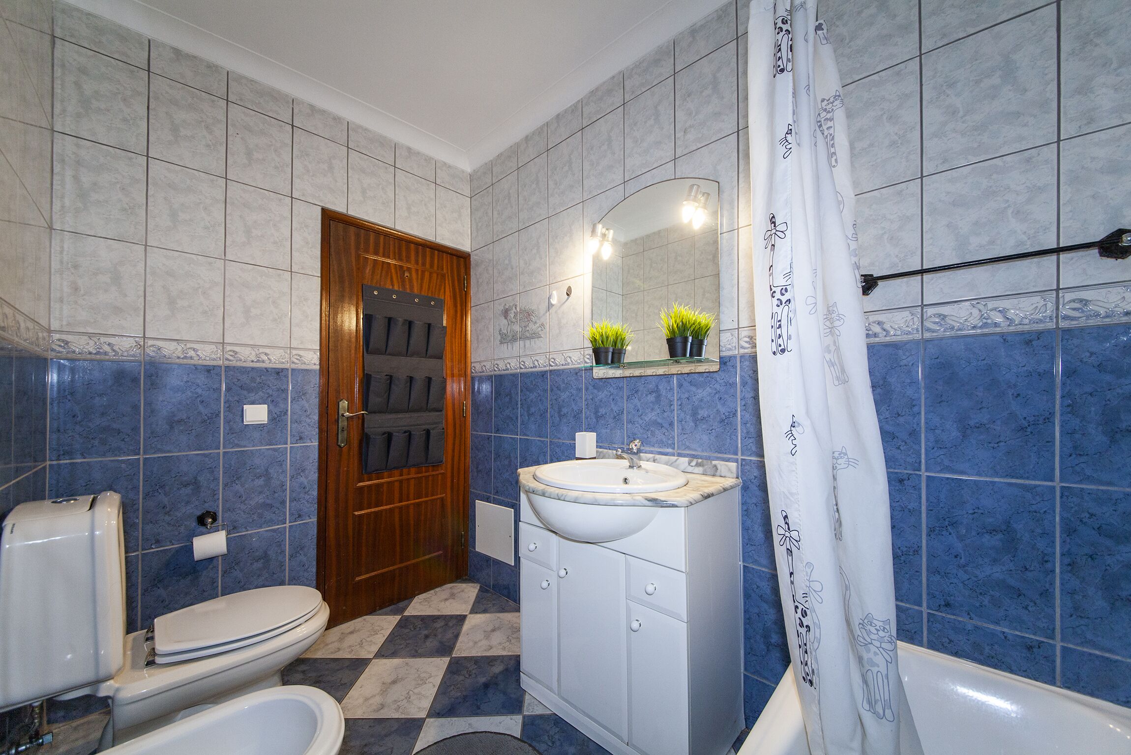 A bathroom with a toilet, sink, and shower area.