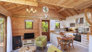A cozy log cabin interior with a living room, dining area, and kitchen. - Porthole Log Cabin (Minehead)