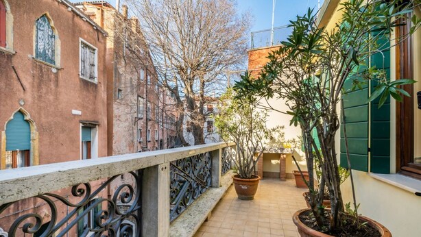 A balcony with a railing, potted plants, and a tiled floor. - GuestHost - Large and bright 145sqm apartment with terrace, located in the center of Venice (sestriere Castello), 5 mins from San Marco and Rialto Bridge and 2mins from the lively Campo S.Maria Formosa. Located on the second floor, without lift, of a Ven (Venice)