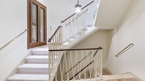 A staircase with white steps, a wooden door, and a metal railing. - GuestHost - Large and bright 145sqm apartment with terrace, located in the center of Venice (sestriere Castello), 5 mins from San Marco and Rialto Bridge and 2mins from the lively Campo S.Maria Formosa. Located on the second floor, without lift, of a Ven (Venice)