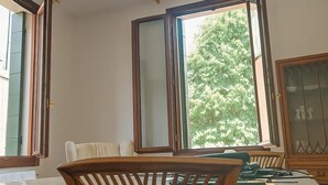 A room with a large window, a wooden chair, a cabinet, and a radiator. - GuestHost - Large and bright 145sqm apartment with terrace, located in the center of Venice (sestriere Castello), 5 mins from San Marco and Rialto Bridge and 2mins from the lively Campo S.Maria Formosa. Located on the second floor, without lift, of a Ven (Venice)