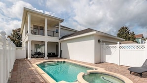 Una casa de dos pisos con piscina y jacuzzi.