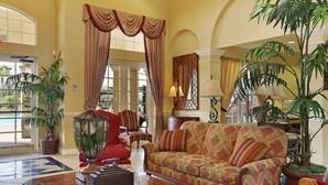 Eine großzügige Lobby mit einer großen Couch, einem Couchtisch und Topfpflanzen.