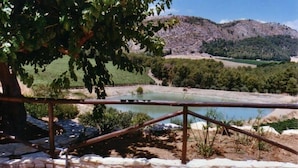 Valla de madera rústica con vistas a un lago y montañas al fondo.