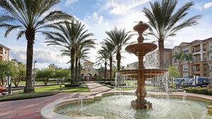 A fountain surrounded by palm trees and a brick pathway. - Beautiful Deluxe Condo [cdc Compliant] 3008 (Orlando)