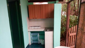 A compact kitchen with wooden cabinets, a sink, and a small refrigerator. - Villaggio Mediterraneo (Scalea)
