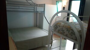 A room with bunk beds, a small desk, and a window with curtains. - Villaggio Mediterraneo (Scalea)