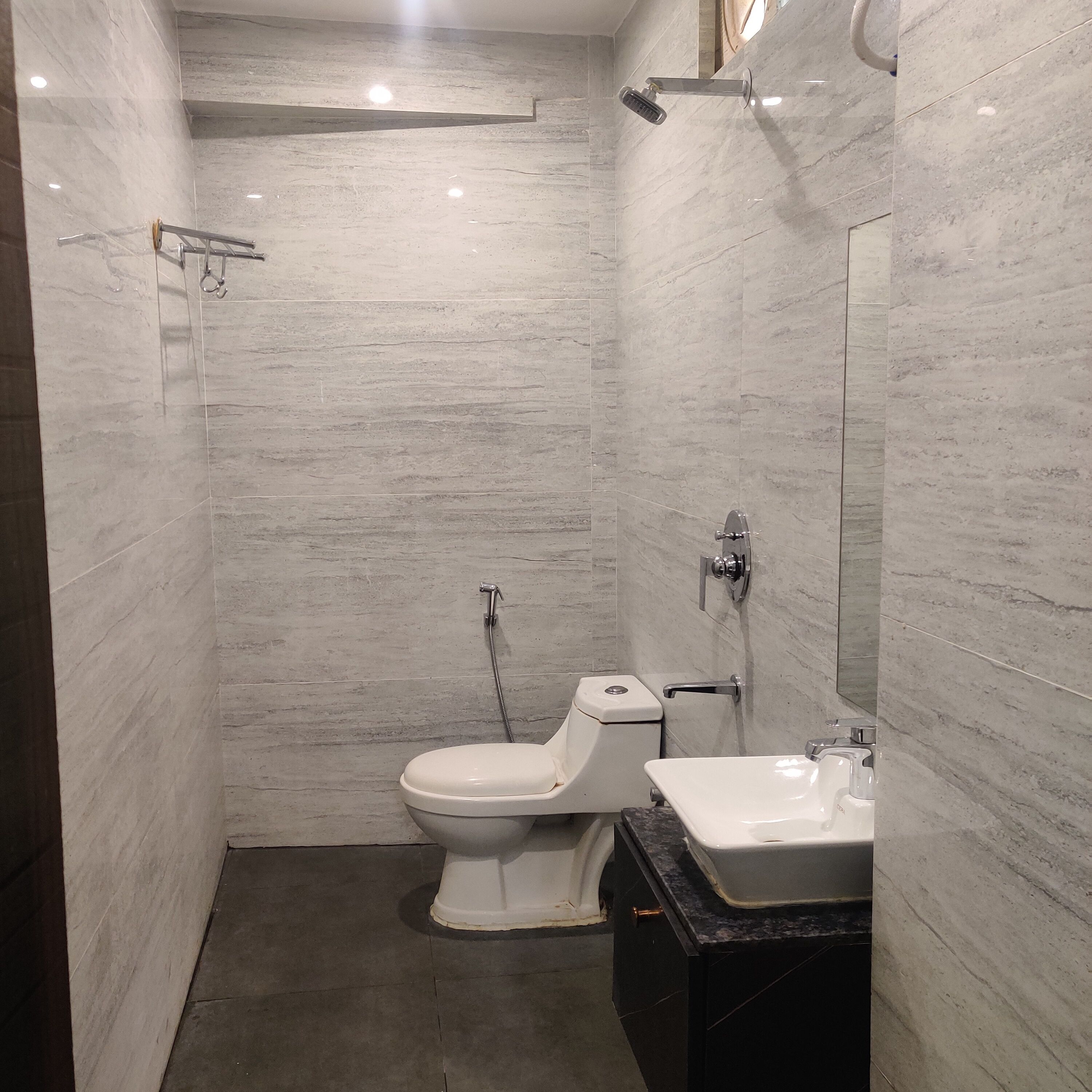A modern bathroom with a toilet, sink, and shower.