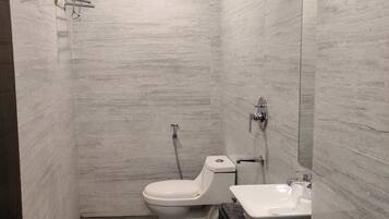 A modern bathroom with a toilet, sink, and shower.
