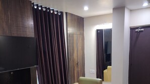 Un salon moderne doté d’un téléviseur à écran plat, de fauteuils en cuir, d’une table basse et d’une cloison en bois foncé.