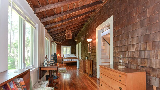Un intérieur rustique en bois, avec un lit, une commode et des étagères.