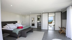 Une chambre à coucher moderne avec un lit, un banc et une vue sur le balcon.