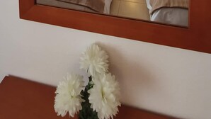 Une chambre d’hôtel avec deux lits, une table de chevet avec une lampe et un miroir au-dessus du lit.