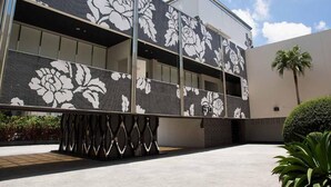 Un edificio moderno con una amplia fachada de vidrio y un llamativo diseño floral en blanco y negro en el exterior.