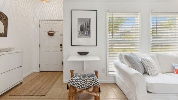 Un soggiorno moderno con un divano bianco, un tavolino in legno e un quadro appeso al muro.