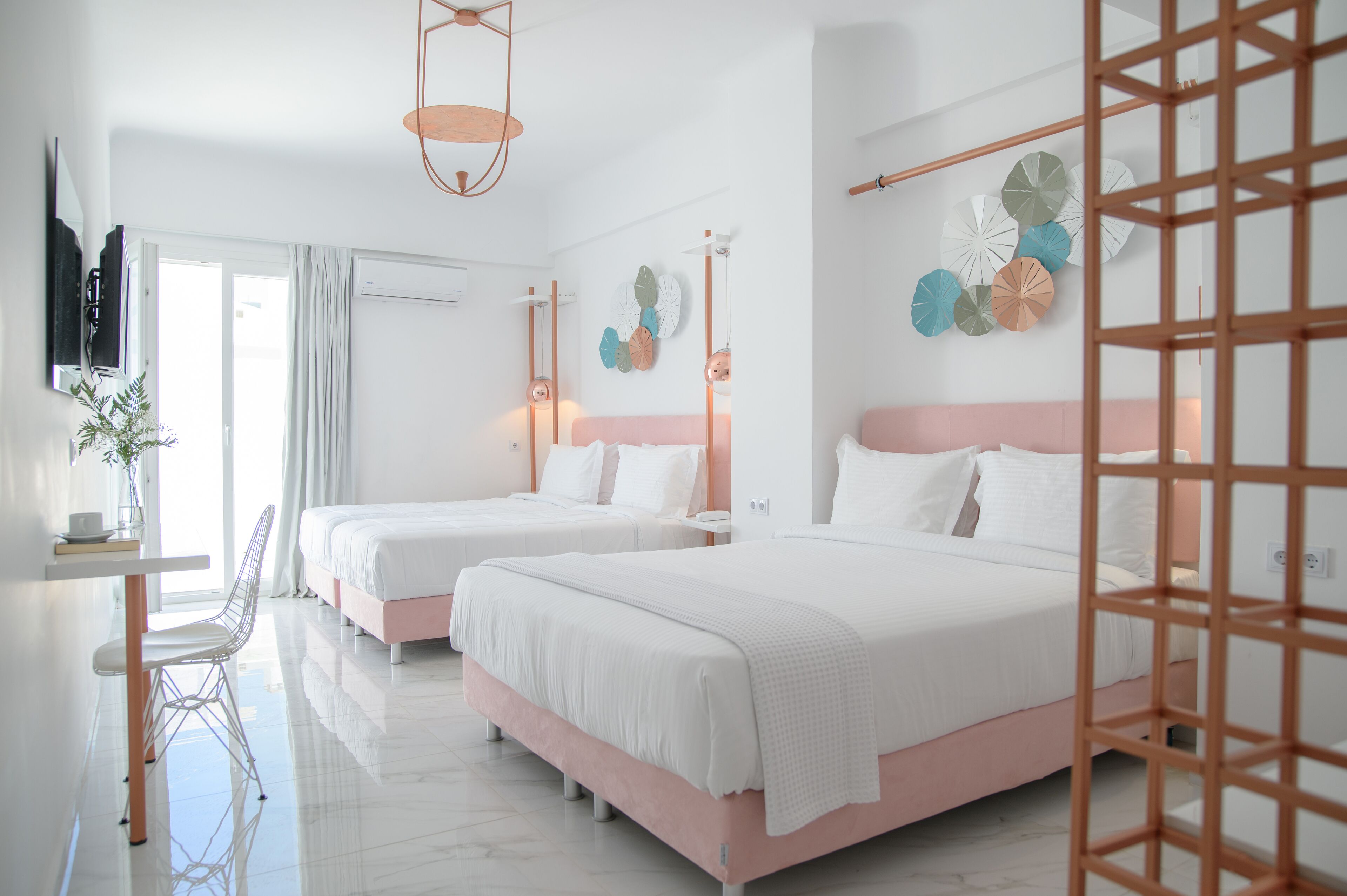 Una habitación de hotel moderna con dos camas, un escritorio y televisión.